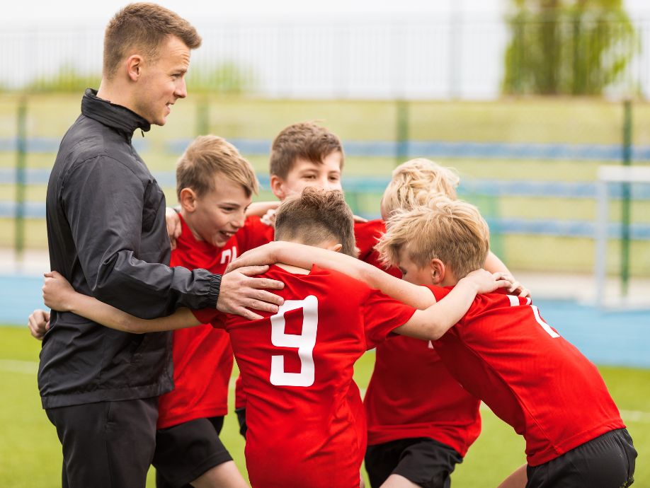 soccer players huddling with coach